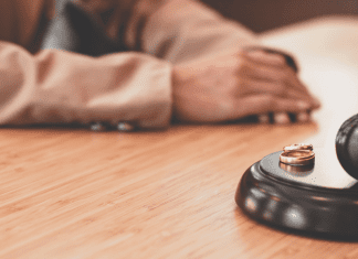 Wedding rings placed near a gavel in a courtroom
