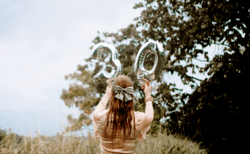 Image of woman holding a 30 balloon in a field