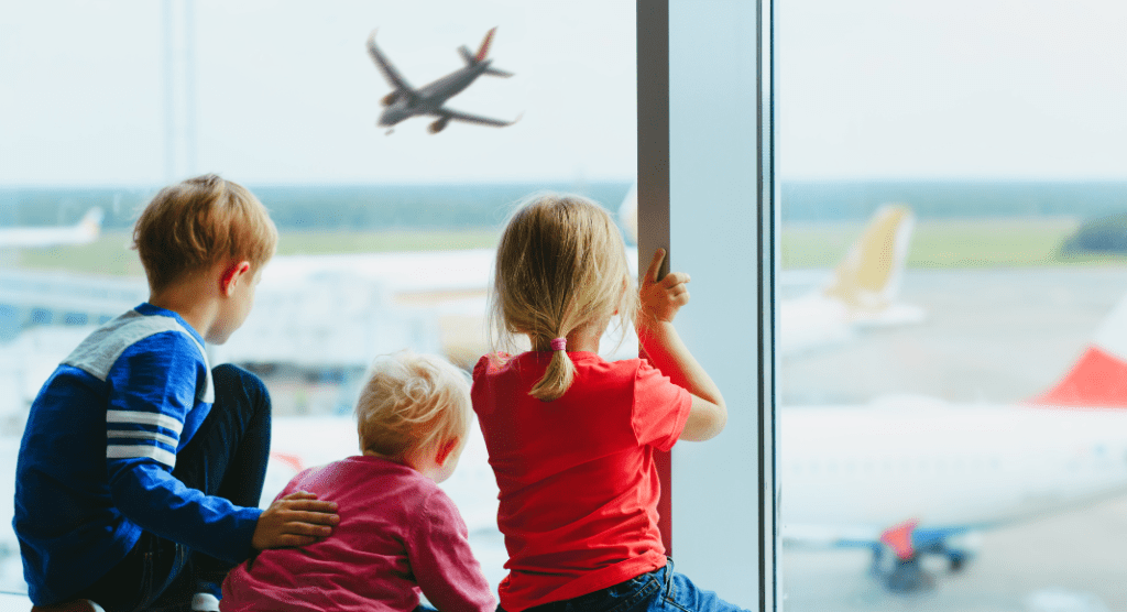 3 kids at airport watching the planes