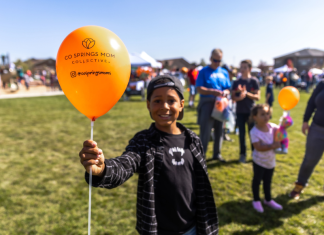 boy holding an orange balloon