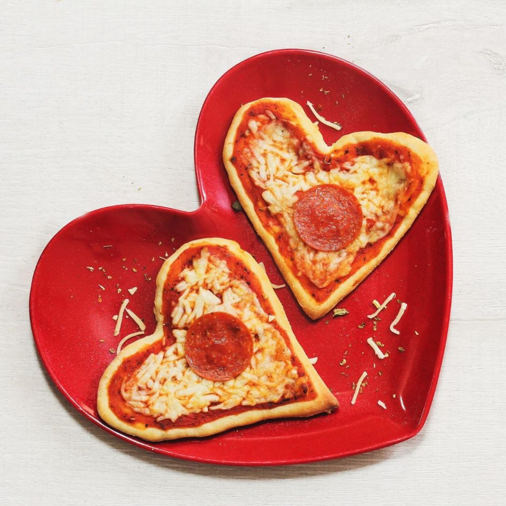 mini heart shaped pizza on a red heart shaped dish