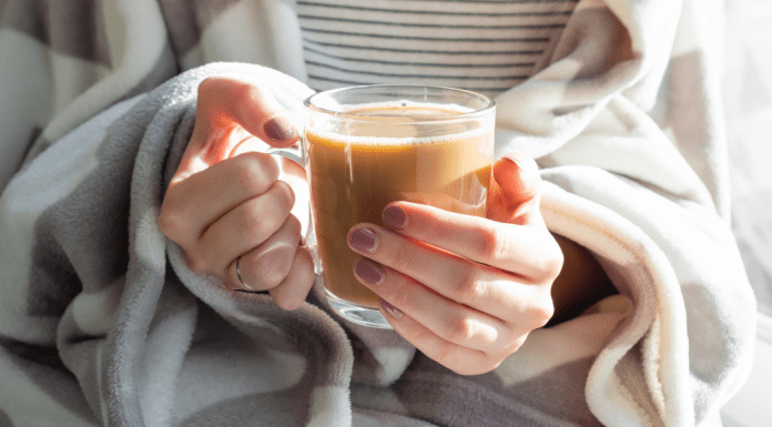 close up of a woman holding a cup of coffee
