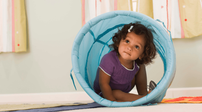 Toddler inside a blue tunnel toy
