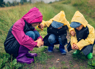 nature experiences featured image. Kids in rain jackets looking at a snail while hiking.