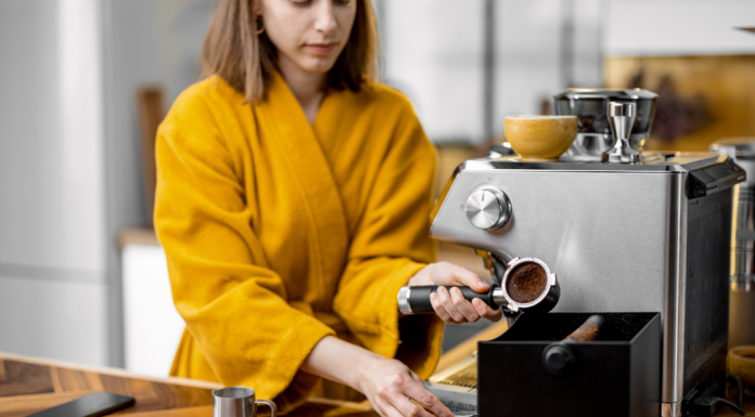 woman in a yellow bathrobe using her at home espresso machine