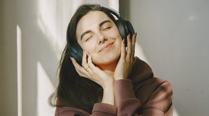 A smiling woman listening to music in her headphones