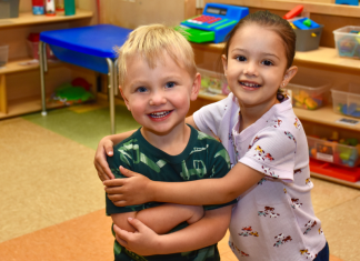 early childhood education. Two preschool students standing together in a classroom at Early Connections.
