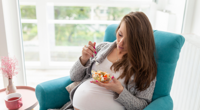pregnant woman sitting in a chair while eating