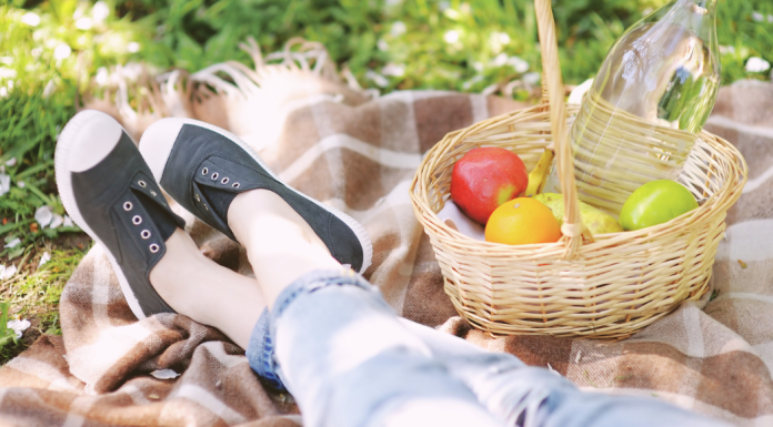 Spring Bucket List Image showing a woman relaxing on a picnic blanket in the grass