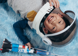 celebrate astronauts featured with young boy wearing an astronaut costume and holding a rocket