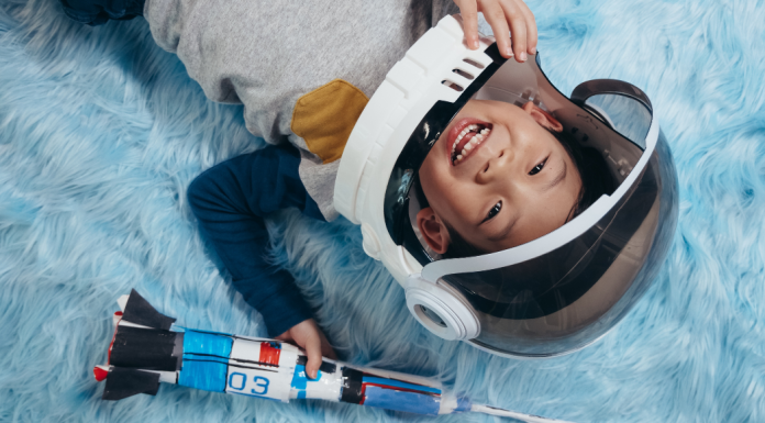 celebrate astronauts featured with young boy wearing an astronaut costume and holding a rocket